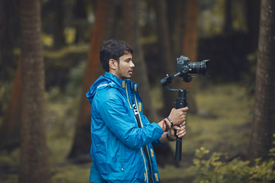 Camera operator filming outdoors with a cinema camera on a gimbal