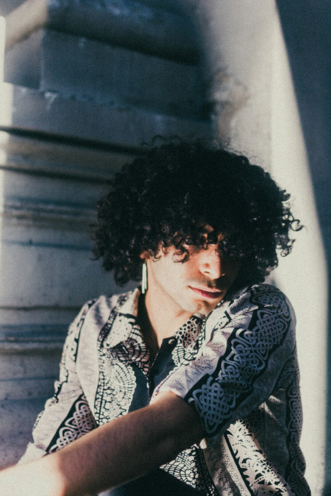 Portrait of a man with curly hair in a patterned shirt